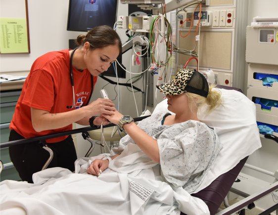 female doctor checking patients hand in hospital - hands-on work is one of 10 reasons to become a doctor