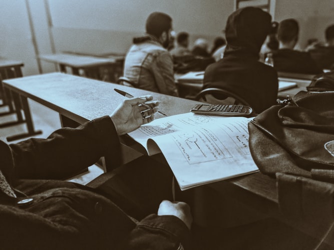 Close-up of a university lecture hall with students and a lecturer.