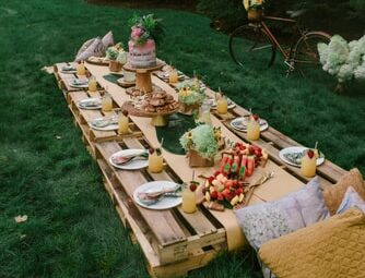 A picnic long table with foods and drinks served.