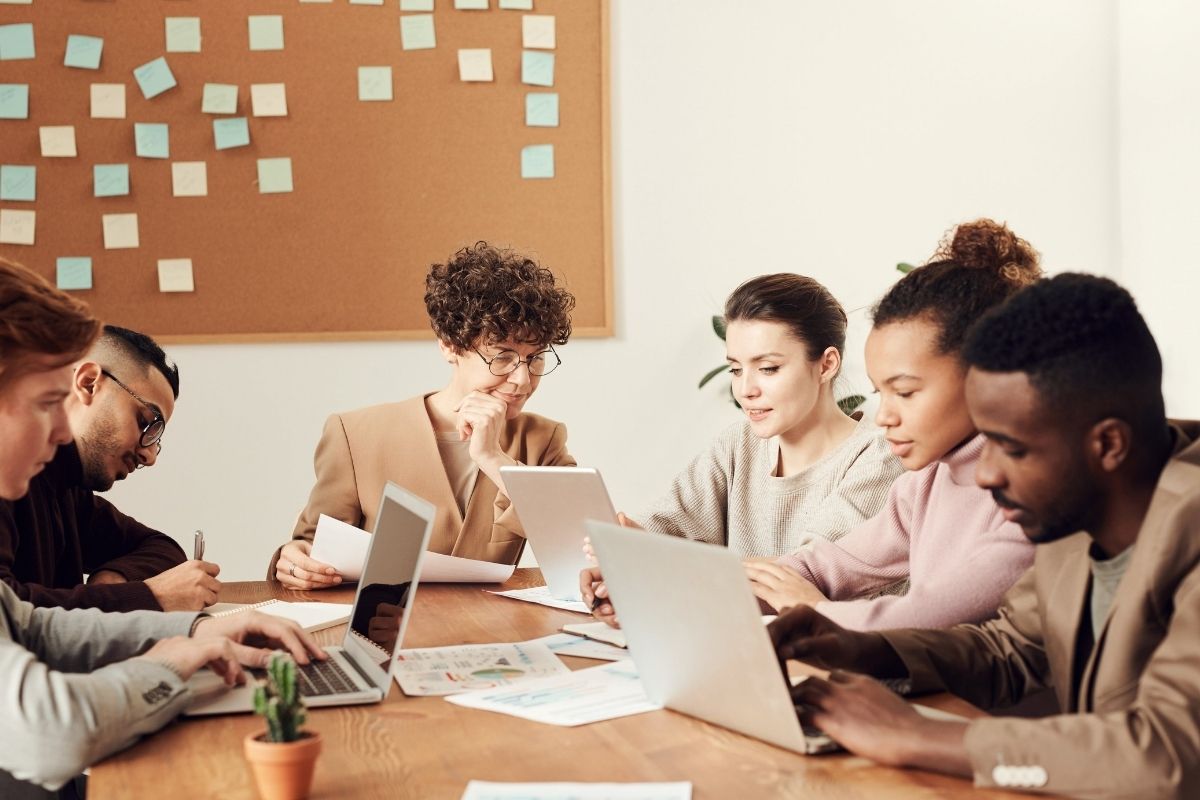 Group of people sitting and typing on their laptops.