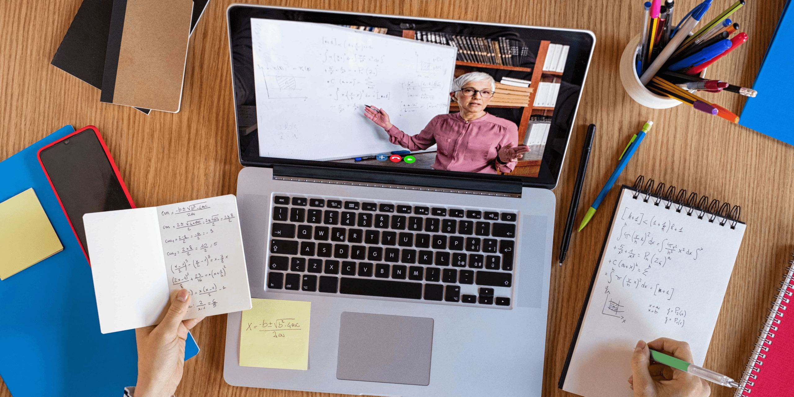 a laptop with a screen showing a woman teaching advanced mathematics on it