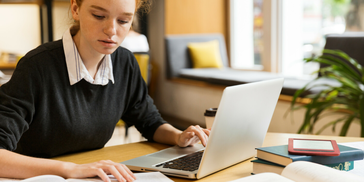 a woman sitting at a desk using a laptop