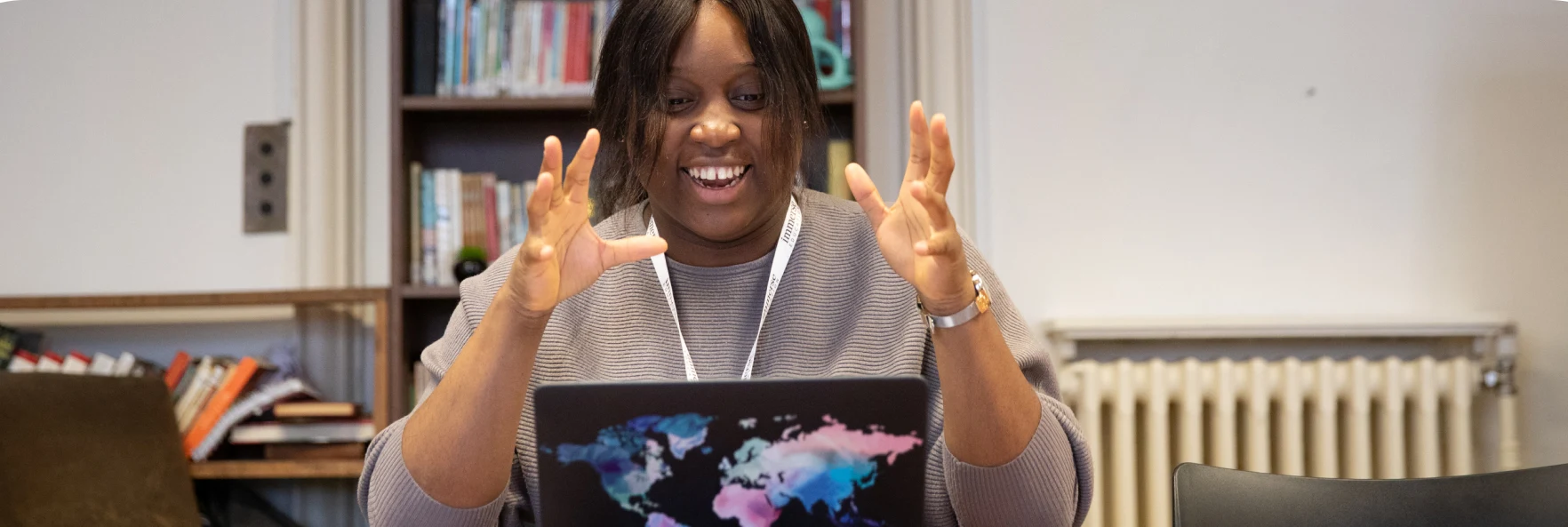 a woman looking at a laptop with her two hands raising up