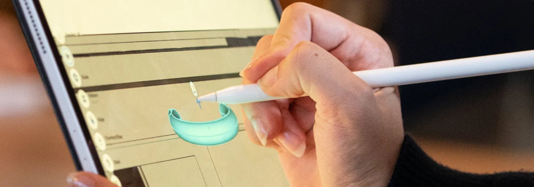 A person holding a stylus pen while adjusting a drawing on her tablet
