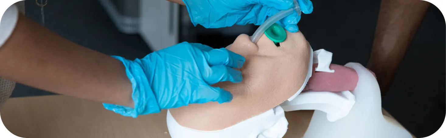 a person wearing gloves and holding a tube to do intubation