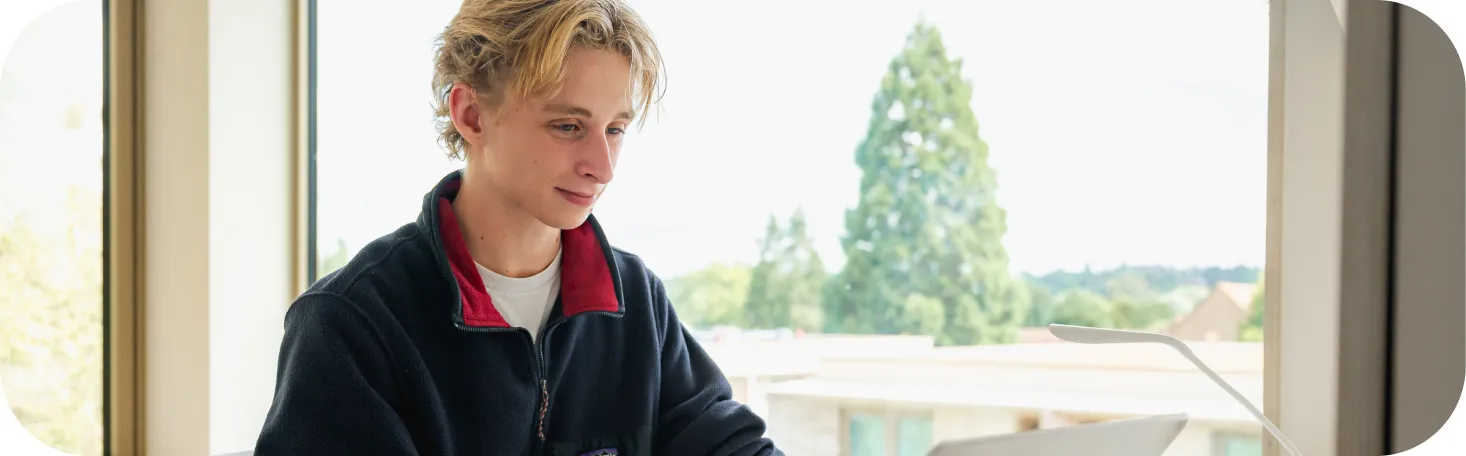 A man smiling at his laptop