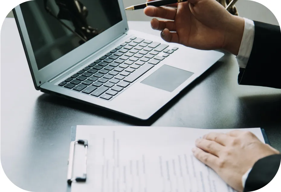 A man writing on a paper with his laptop
