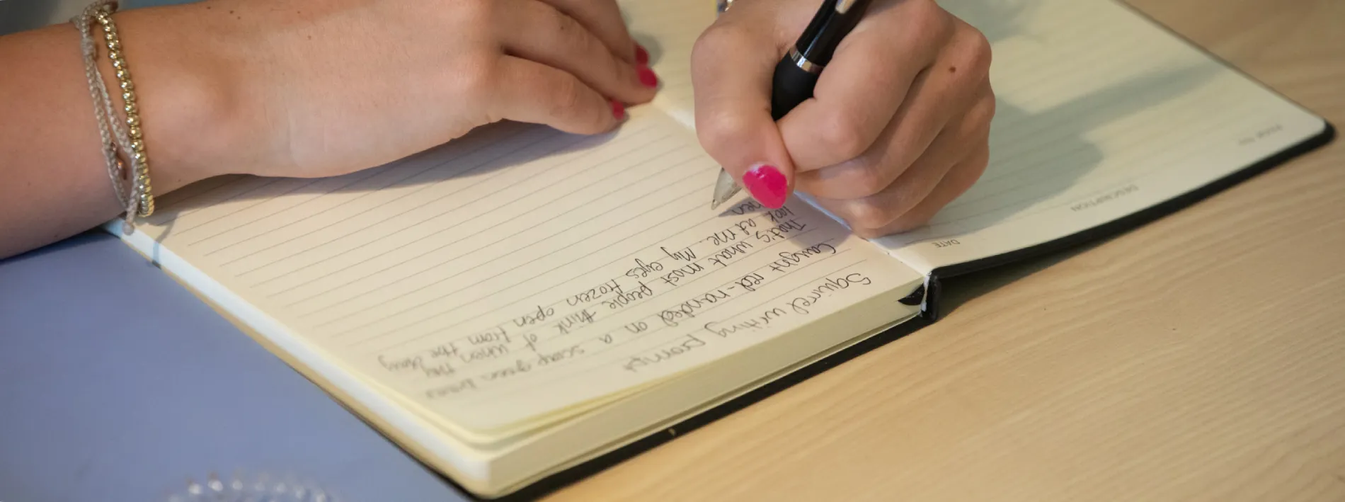 A person writing on a notebook.