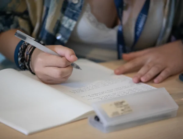 A woman writing on her notebook.