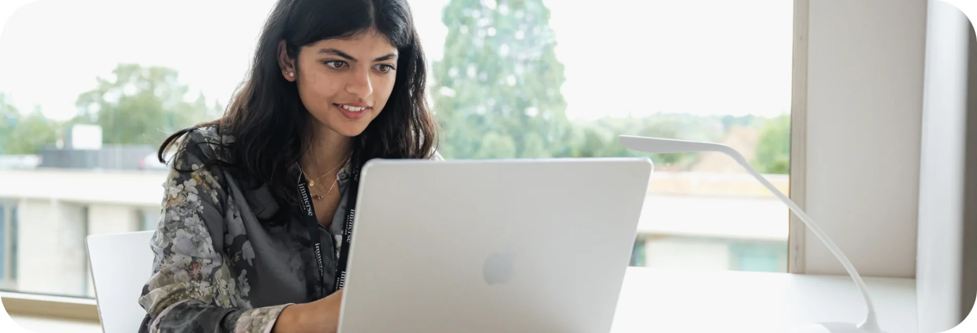 a woman looking at a laptop smiling