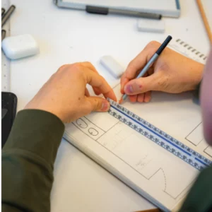 a person draws while using a ruler