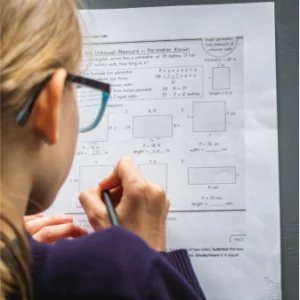 A woman writing on a test paper.