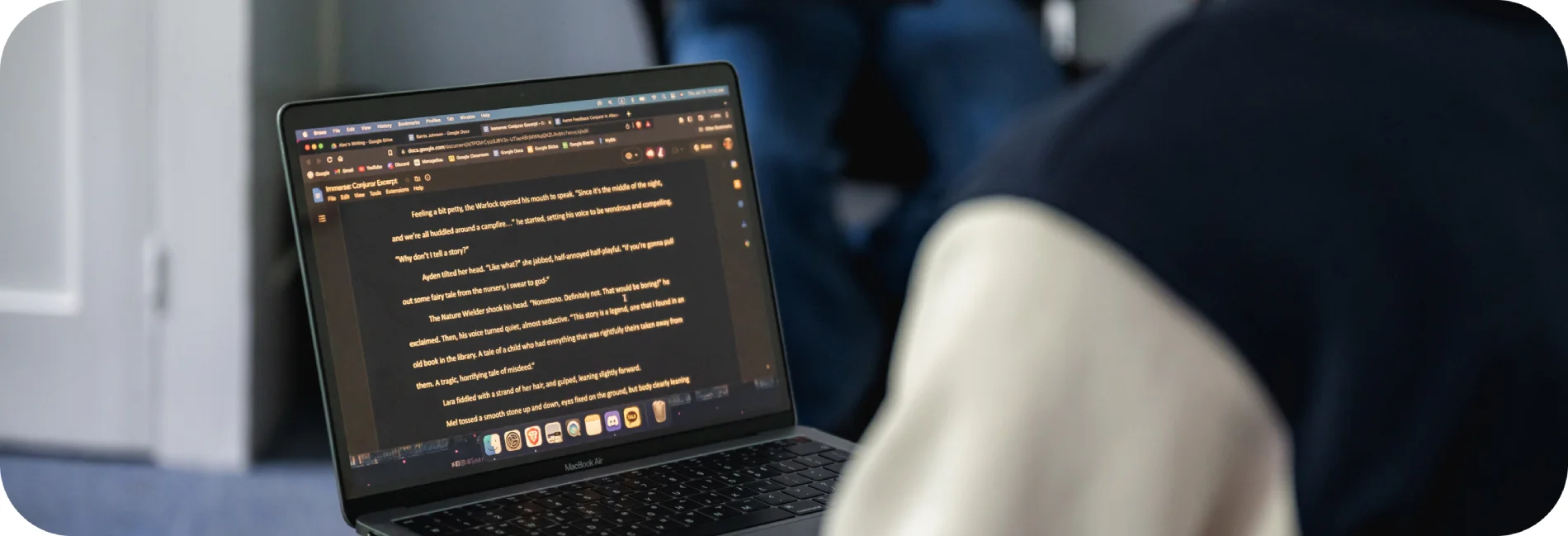 A person typing a document on her laptop.