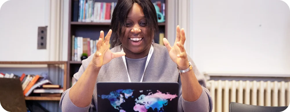 A woman teaching or explaining something looking at her laptop.