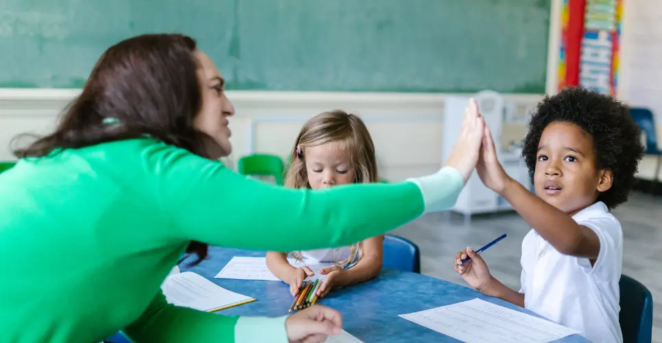 Teacher and children at a nursery - one of the places to complete teaching and childcare work experience