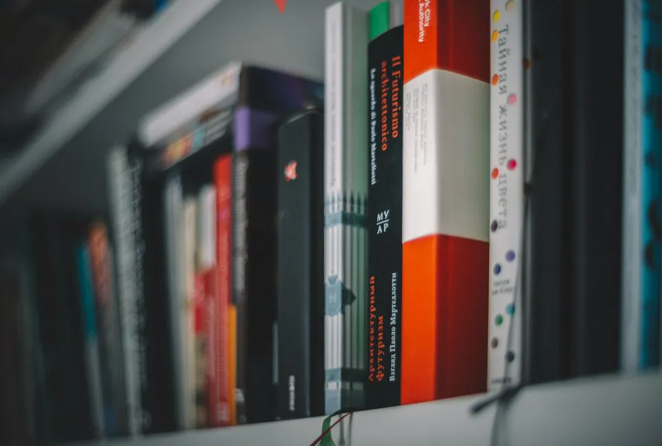 A stack of books and a notebook, representing study materials for an EPQ project.