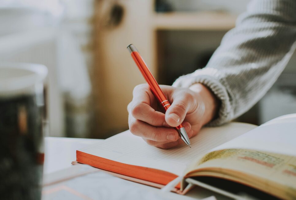 Hand holding a pen writing in study book
