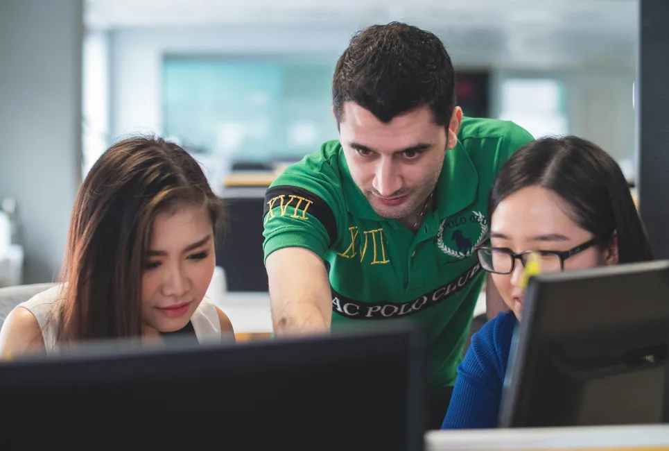 Group of students together around a laptop