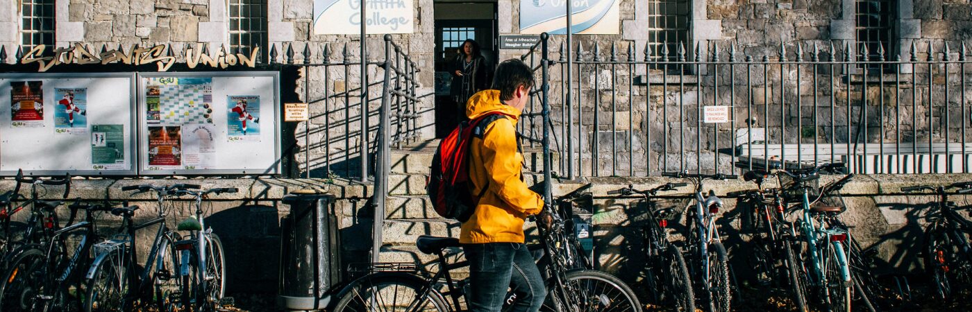 Student on bike next to college in dublin