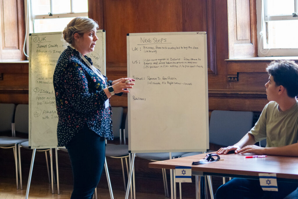 A tutor presenting content on international relations using a whiteboard