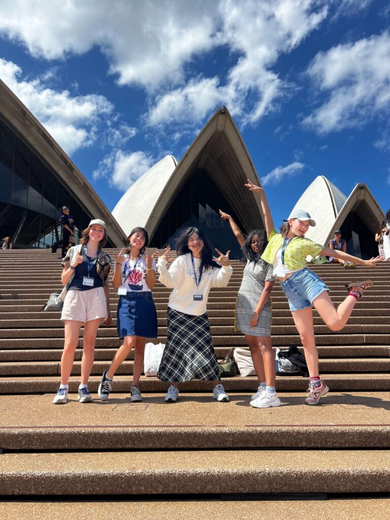 Students posing in front of the Sydney opera house during a Sydney summer school excursion